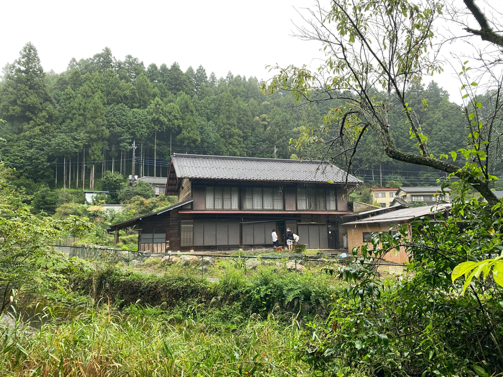 Traditional wooden Japanese farmhouse on a forested hillside in the Tokai countryside
